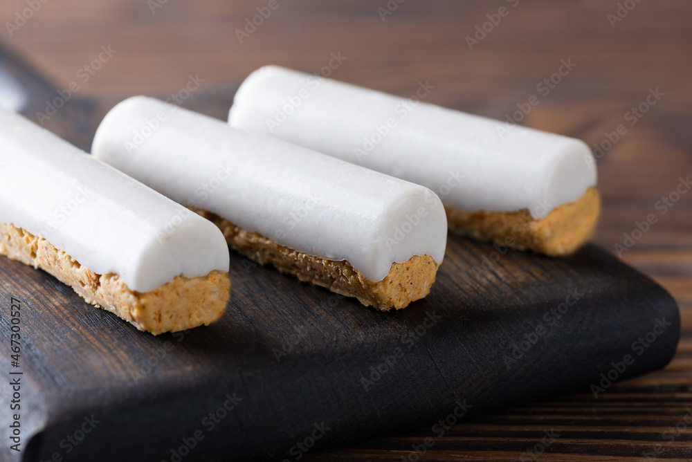Healthy carrot bars with coconut and walnuts on a wooden board. Sugar, gluten and lactose free, vegan, raw. Healthy carrot bars with coconut and walnuts on a wooden board. Sugar, gluten and lactose free, vegan, raw.