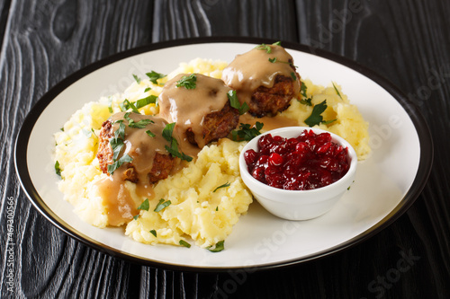 Foto Finnish cuisine delicious meatballs with gravy served with mashed potatoes and lingonberry jam close-up in a plate on the table