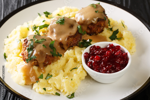 Foto Meatballs Lihapullat with mashed potatoes and lingonberry jam close-up in a plate on the table