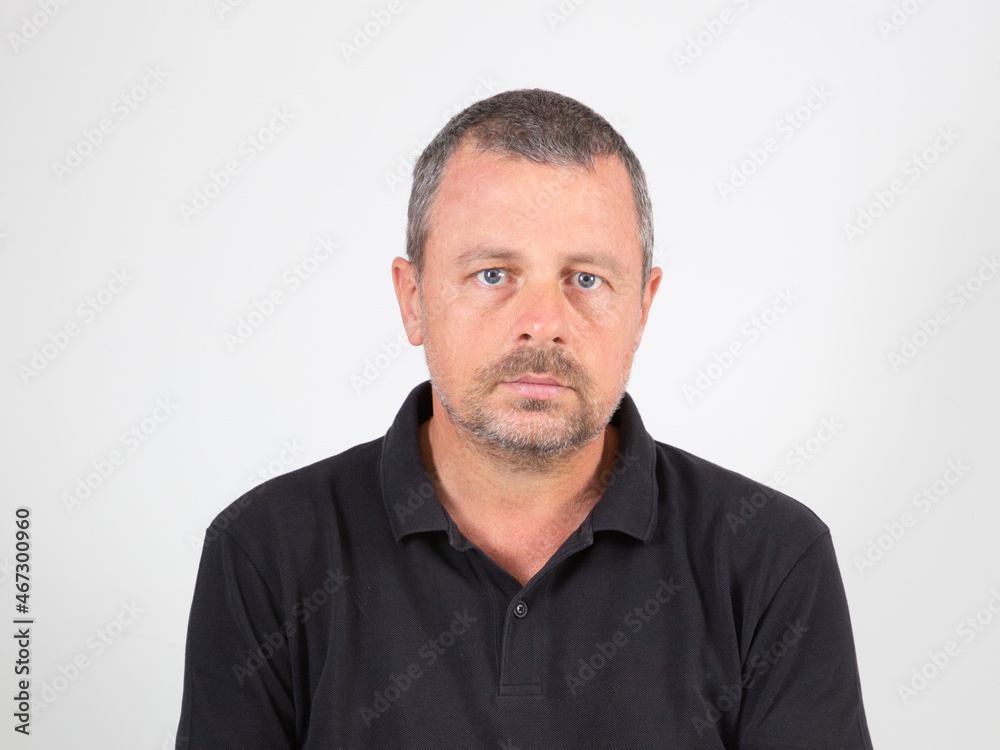 Man in black t-shirt looking face on grey background Man in black t-shirt looking face on grey background