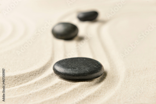 Black spa stones on light sand