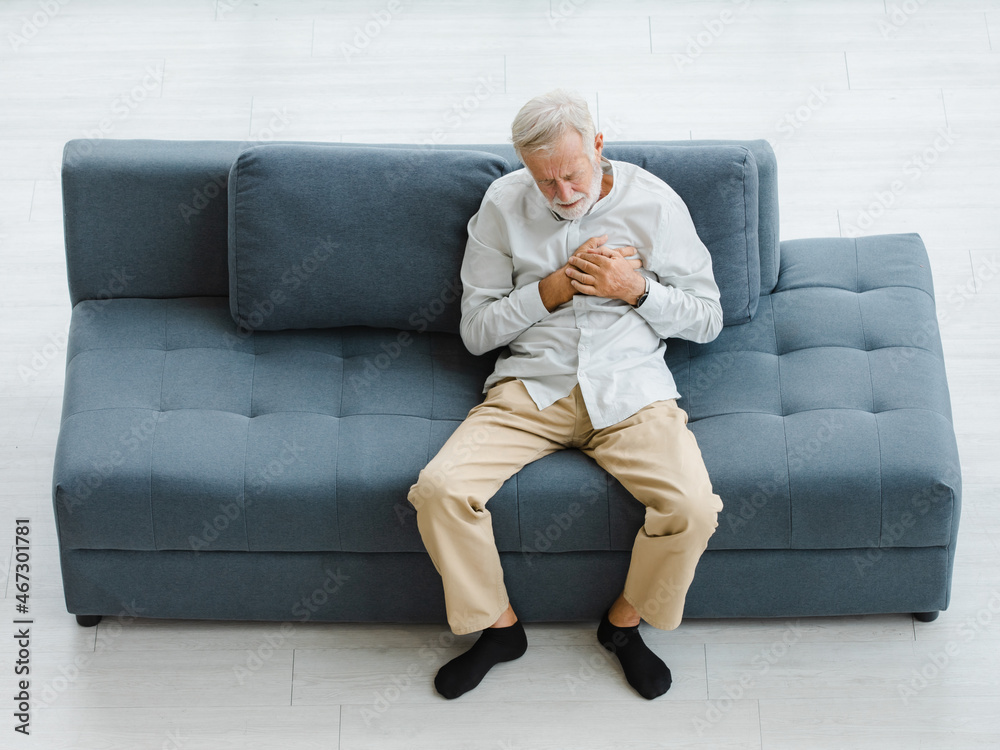 Caucasian old senior elderly gray hair and bearded man lying down close eyes on sofa in living room at home alone holding hands on chest suffering from sudden problem painful emergency heart attack Caucasian old senior elderly gray hair and bearded man lying down close eyes on sofa in living room at home alone holding hands on chest suffering from sudden problem painful emergency heart attack