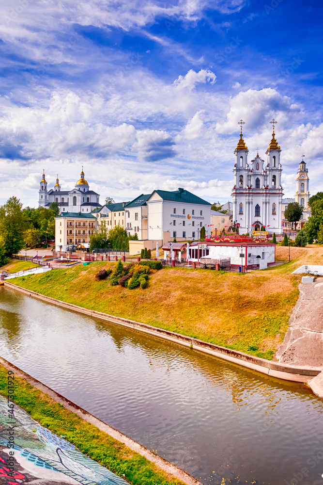 Vitebsk, Belarus - August 1, 2021: Vitebsk City Skyline with Resurrection Church, Holly Assumption Cathedral and Town Hall Across The Vitba River in Vitebsk, August 1, 2021
