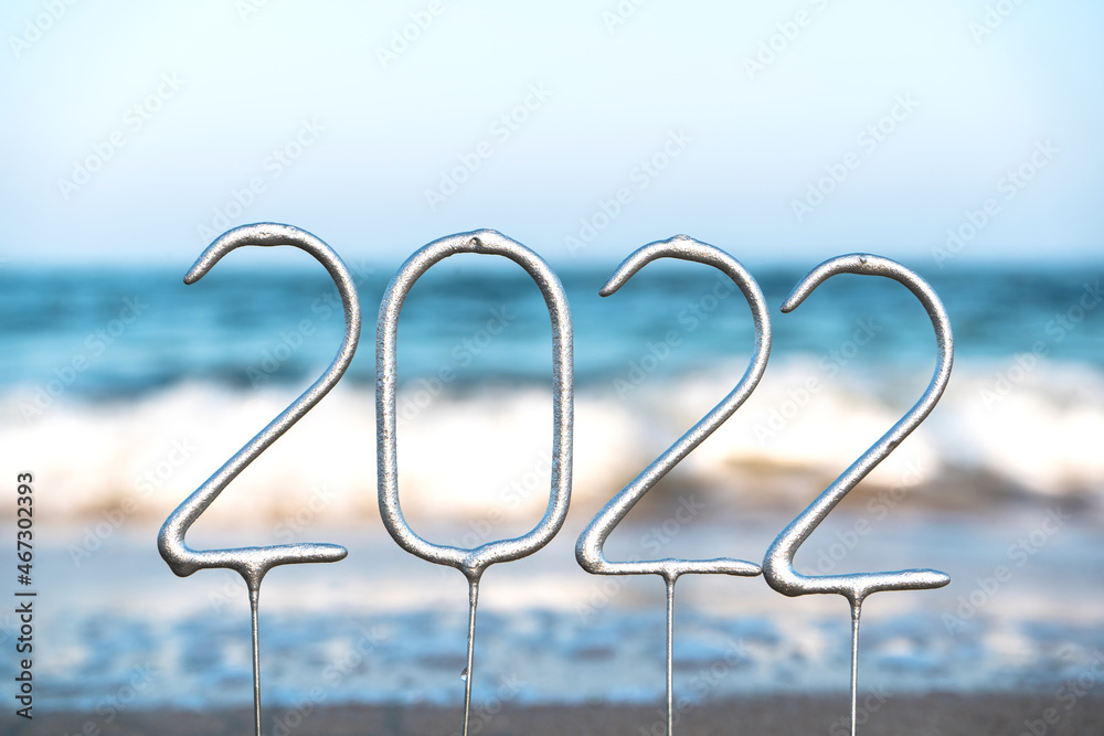 Figures of the upcoming New Year 2022 on the background of waves on the beach, travel concept, New Year celebration in an exotic country Figures of the upcoming New Year 2022 on the background of waves on the beach, travel concept, New Year celebration in an exotic country