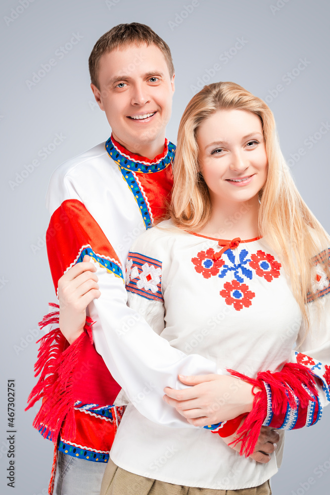 Loving Embraced Caucasian Couple in National Belarussian and Russian Decorated Costumes. Against White Background. Loving Embraced Caucasian Couple in National Belarussian and Russian Decorated Costumes. Against White Background.