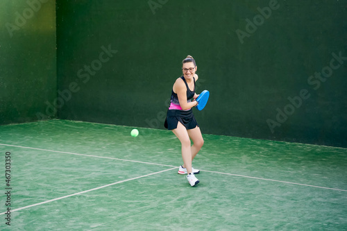 Sportswoman hitting padel ball with racket © JoseIMartin