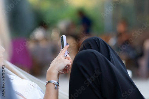 Female lands holding a smartphone while reading or texting.