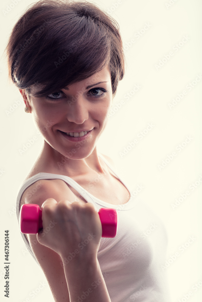 Happy focused young woman working out with dumbbell weights Happy focused young woman working out with dumbbell weights