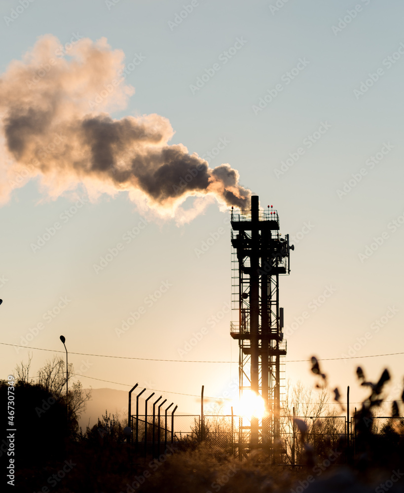 CHP with chimneys, industrial facilities and residential buildings. Environmental pollution. Evening, sunset.