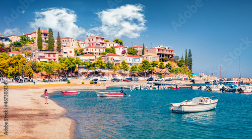 Fototapeta Naklejka Na Ścianę i Meble -  Promenade on the shore of Astros port. Sunny summer seascape of Myrtoan Sea. Picturesque evening scene of Arcadia region, Greece, Europe. Traveling concept background.
