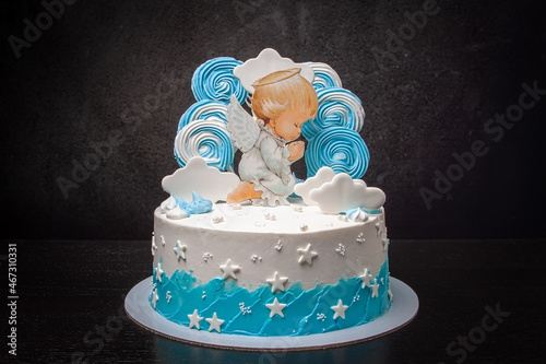 Close-up of a themed cake with an angel and white clouds, for the christening of a baby. Baptism of a newborn photo