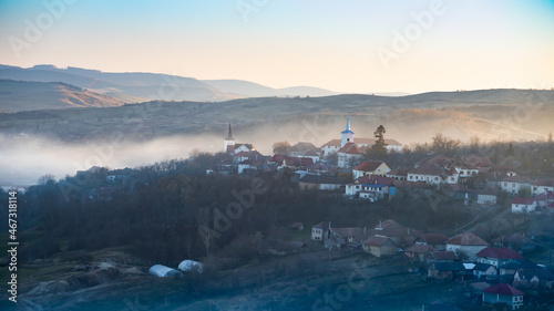  Sic, Romania. Foggy sunset over the small village, Transylvania.