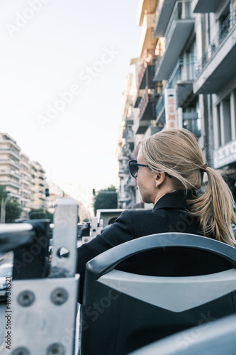 Back view at woman on double-decker sightseeing bus in Thessaloniki, Greece