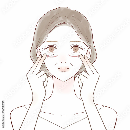 目の下をマッサージしている中年女性