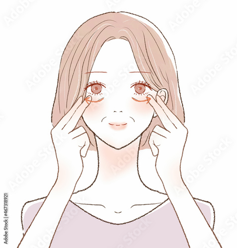 目の下をマッサージしている中年女性