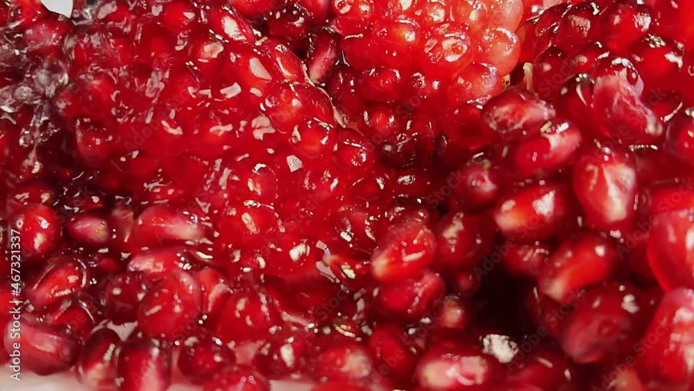 Close-up of the sweet juice flowing down the ripe pomegranate grains Close-up of the sweet juice flowing down the ripe pomegranate grains
