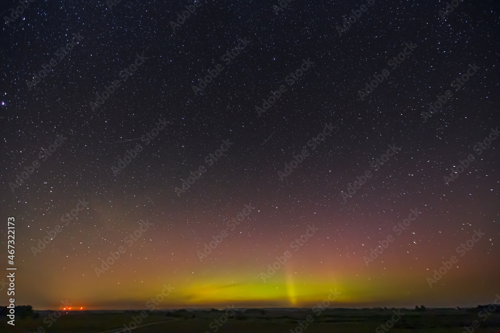 Milky way and Northern lights - Aurora borealis over the fields in Lithuania