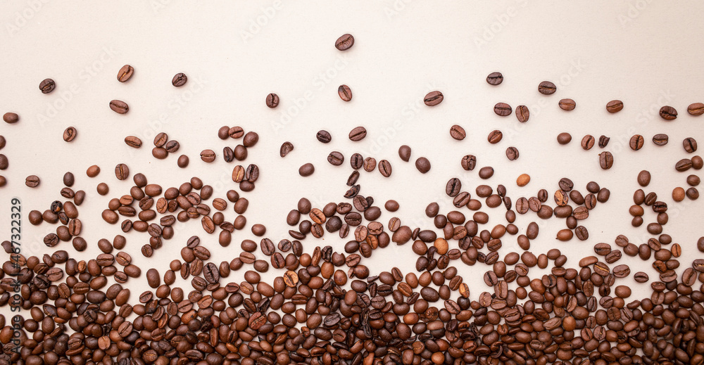 Fototapeta premium Spilled coffee on light brown background. Lots of coffee. Background. Coffee beans.