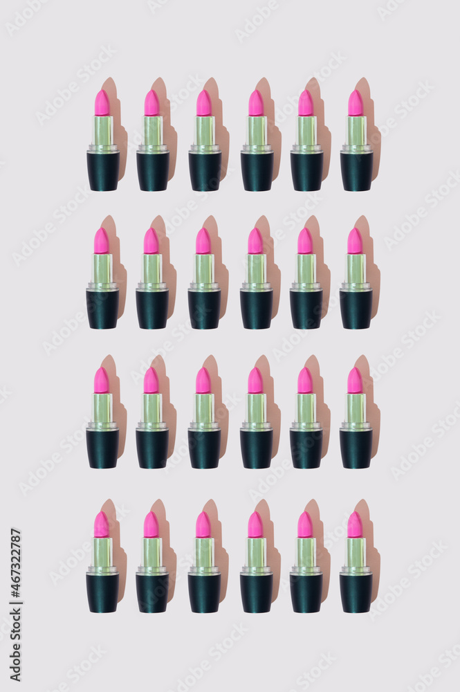 A pattern made of pink lipstick on a pastel pink background. .Aesthetic makeup cosmetic arrangement concept. A pattern made of pink lipstick on a pastel pink background. .Aesthetic makeup cosmetic arrangement concept.