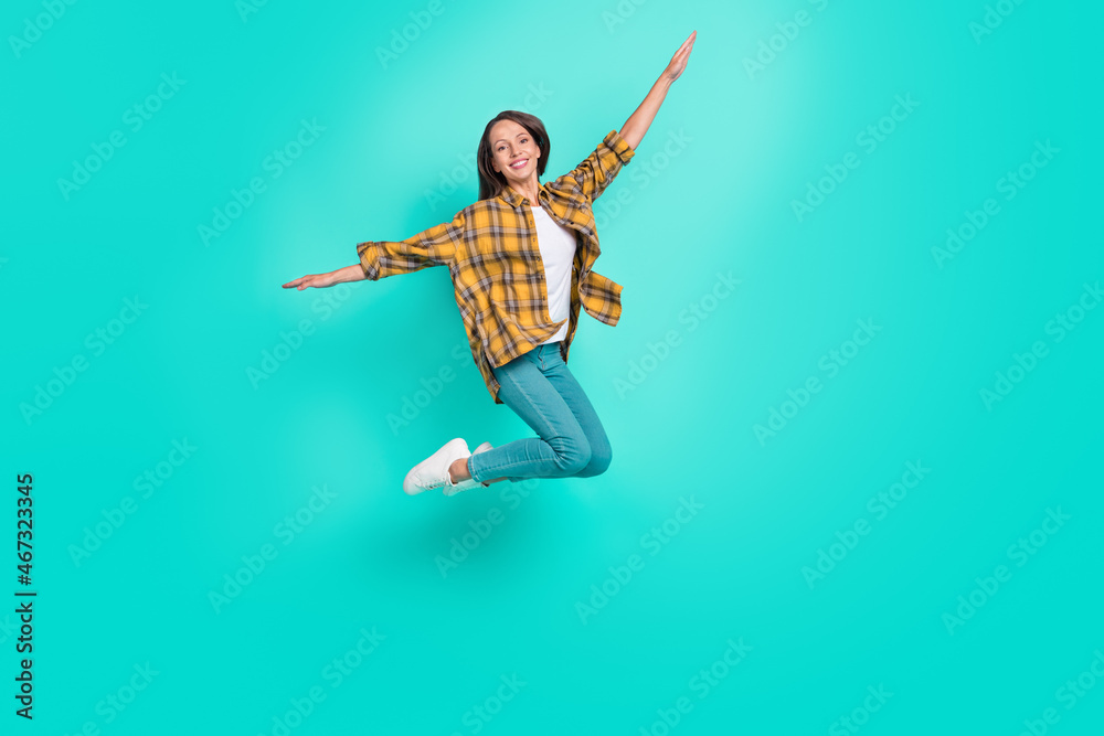 Full body photo of young cool brunette lady jump wear shirt jeans sneakers isolated on turquoise background