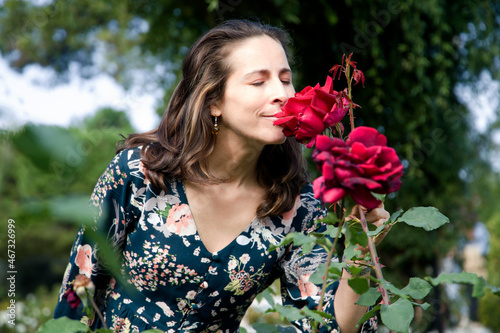 woman smelling a rose with her eyes closed