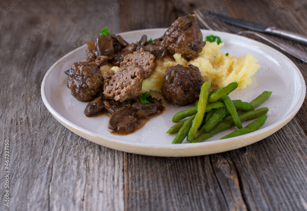 Plate with meatballs, mashed potatoes and green beans served in a delicious mushroom sauce Plate with meatballs, mashed potatoes and green beans served in a delicious mushroom sauce