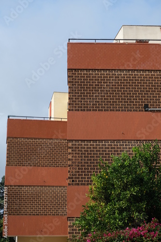 Brick sunscreen. Red brick sunscreen.Building wall covered with sunscreen bricks. Cagliari, Sardinia, Italy.