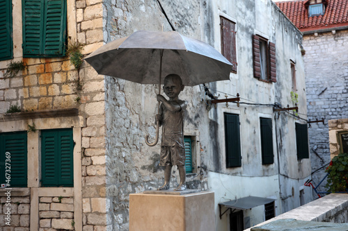 Statue of a kid holding an umbrella in Sibenik, Croatia photo