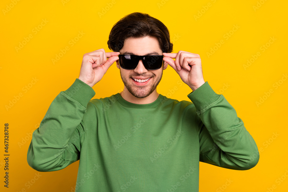 Photo of young happy cool positive man wear sunglass green sweater smile isolated on yellow color background