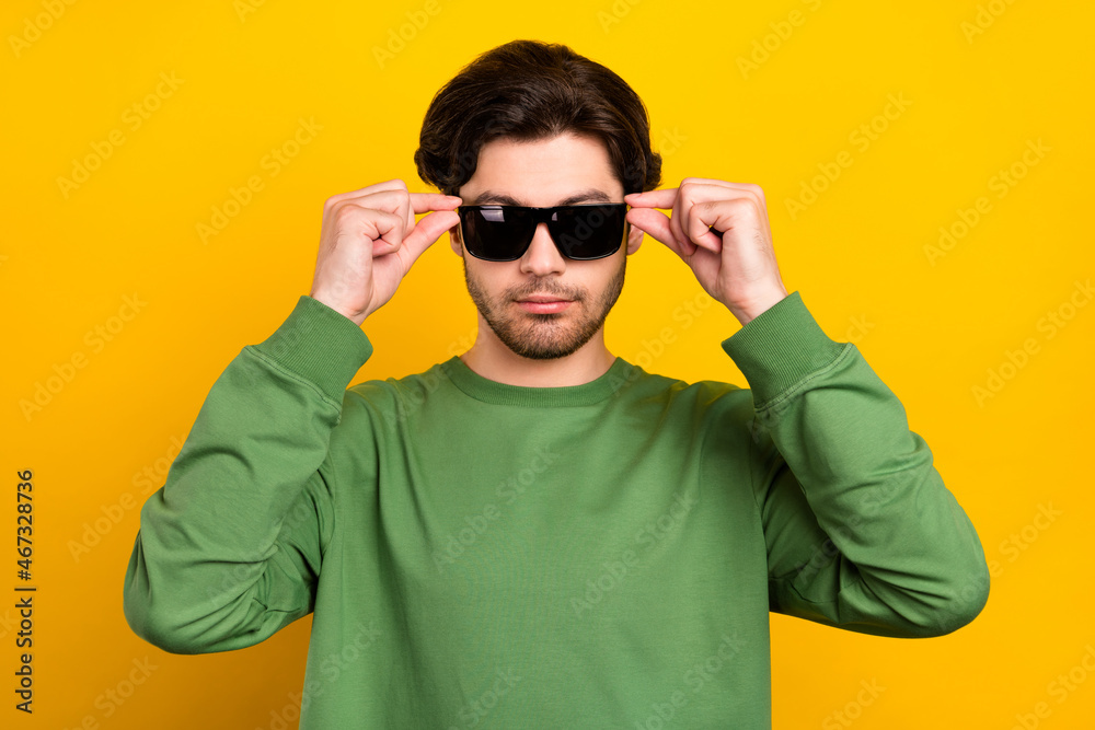 Photo of young charming calm peaceful man wear sunglass cool attractive isolated on yellow color background Photo of young charming calm peaceful man wear sunglass cool attractive isolated on yellow color background