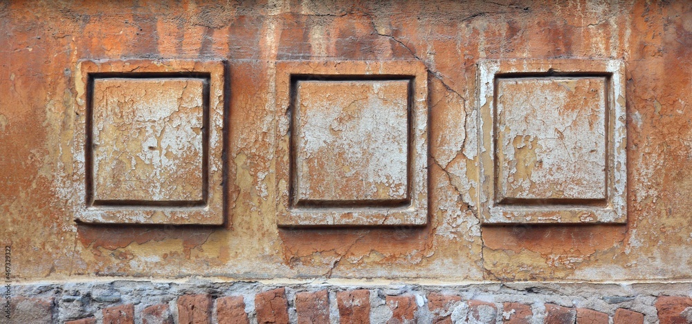 Grunge wall of an abandoned house with framed square ornaments with cracks, chipped brown painting and moisture over the bricks - weathered texture for an horizontal background banner Grunge wall of an abandoned house with framed square ornaments with cracks, chipped brown painting and moisture over the bricks - weathered texture for an horizontal background banner
