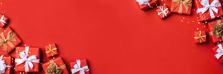 Gift boxes with white and brown bows on a red backdrop.