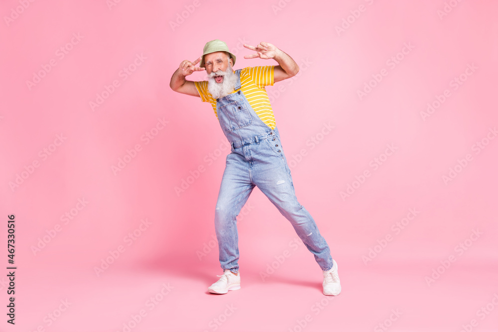 Full length body size view of attractive cheerful man showing v-sign having fun isolated over pink pastel color background Full length body size view of attractive cheerful man showing v-sign having fun isolated over pink pastel color background