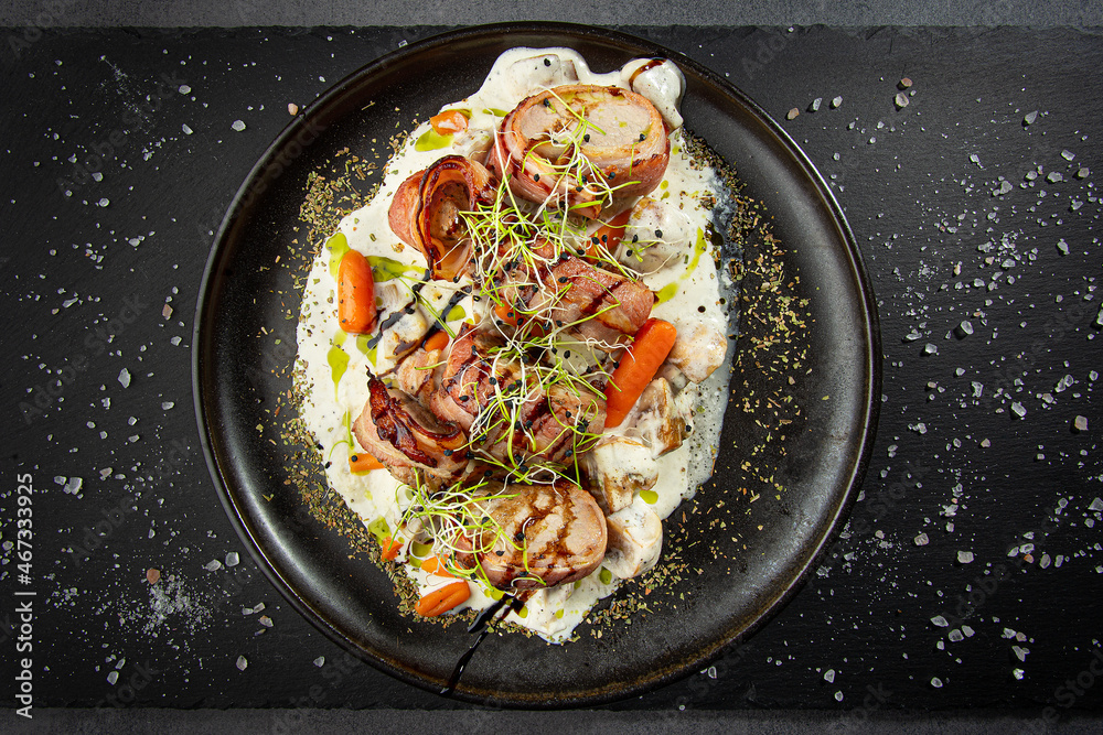 Juicy pork medallions wrapped in bacon, served ith cream souce, baby carrots and sprouts Juicy pork medallions wrapped in bacon, served ith cream souce, baby carrots and sprouts