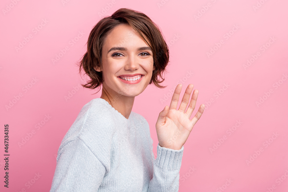 Photo of cheerful happy nice young woman wave hello greeting smile enjoy cool isolated on pink color background Photo of cheerful happy nice young woman wave hello greeting smile enjoy cool isolated on pink color background