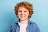 Photo of positive glad nice small ginger boy toothy beaming smile wear denim jacket isolated blue color background