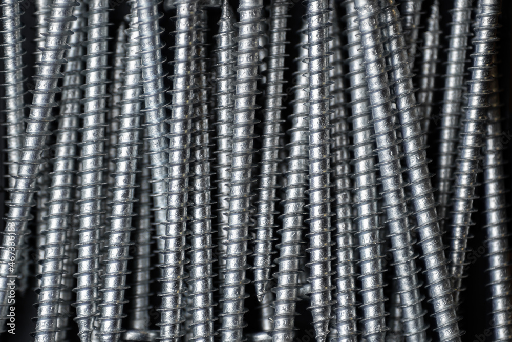 Pile of screws made of steel as a background
