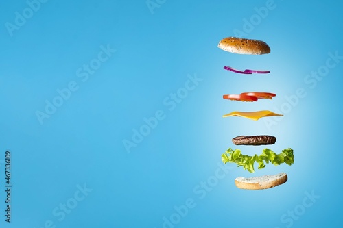 Beef burger split in mid air with space to write on the left of the picture