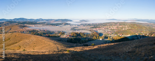 Panoramic view of the tourist town of Zlatibor in the fog on the mountain Zlatibor in Serbia surrounded by peaks breaking through the morning fog in October