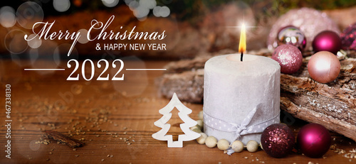 weihnachtskarte mit brennender adventskerze und text merry christmas and happy new year 2022 photo