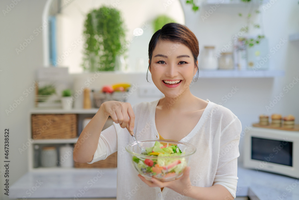 young Asian woman eating salad vegetable in diet concept young Asian woman eating salad vegetable in diet concept
