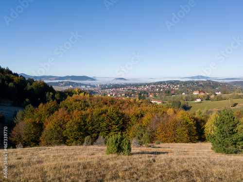 View of the tourist town of Zlatibor in the fog on the mountain Zlatibor in Serbia surrounded by peaks breaking through the morning fog in October
