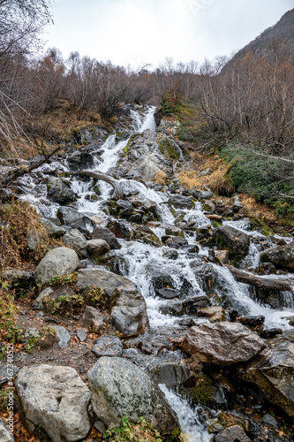 travel, walk, nature, landscape, valley, gorge, mountains, slope, rocks, boulders, waterfall, water, stream, trees, christmas trees, vegetation, fallen foliage, autumn, cloudy day