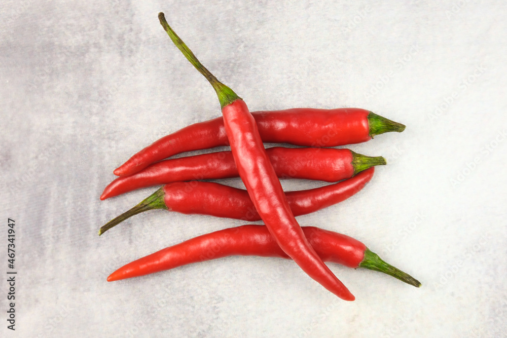 Bunch of red hot chili peppers on a gray background. Spice for cooking spicy dishes.