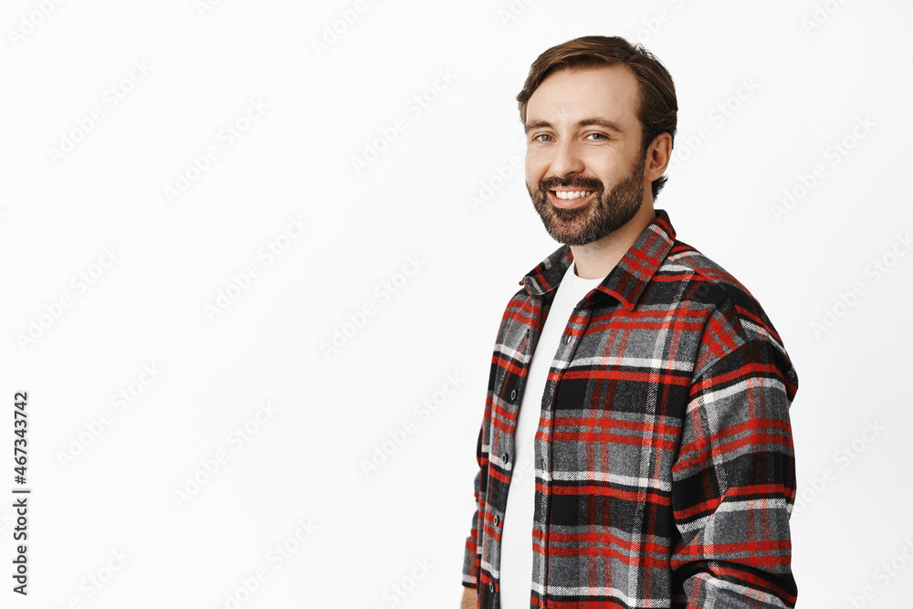 Portrait of handsome happy adult man with beard, looking at camera and smiling, standing in checked shirt over white background Portrait of handsome happy adult man with beard, looking at camera and smiling, standing in checked shirt over white background