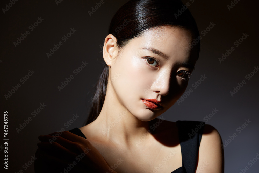 Fototapeta premium 若い女性の光と影のエレガントなビューティーポートレート