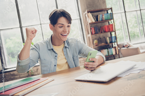 Portrait of attractive cheerful guy learner using gadget searching information having fun at loft industrial interior indoors