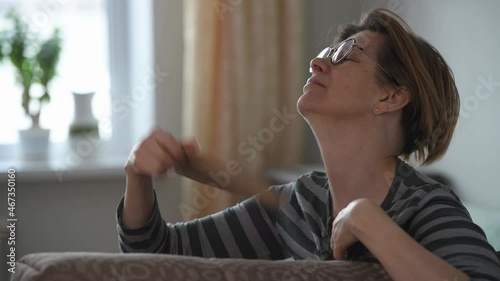 A mature middle-aged woman fanning herself. Health problems, menopause.  photo