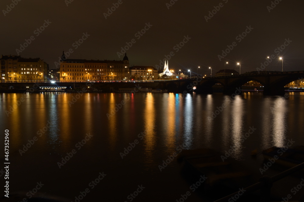 Night city with river and church, street lights reflected in water surface, beautiful landscape