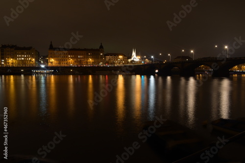 Night city with river and church, street lights reflected in water surface, beautiful landscape